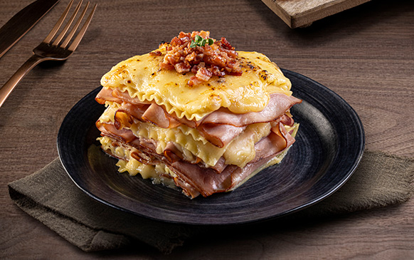 lasagna Lasaña de jamón y queso en plato oscuro